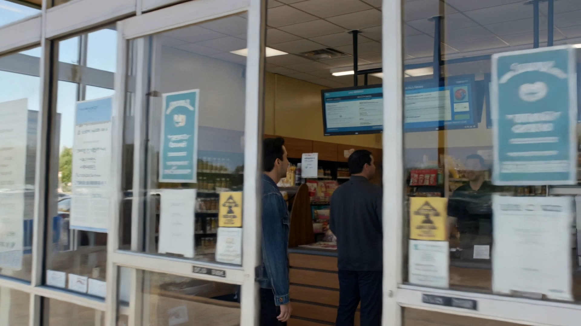 Shoppers in a convenience store looking up at a niklus board showing live lottery jackpots.